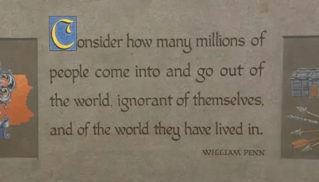Photo: Museum panel with William Penn quote about being “ignorant of themselves,” flanked by a Pennsylvania crest and longhouse illustration. A quote indicating that you should expand your world