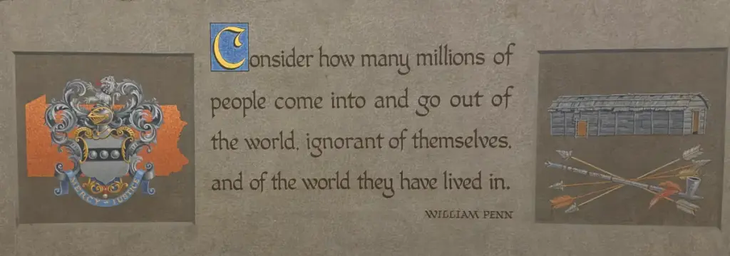 Photo: Museum panel with William Penn quote about being “ignorant of themselves,” flanked by a Pennsylvania crest and longhouse illustration. A quote indicating that you should expand your world