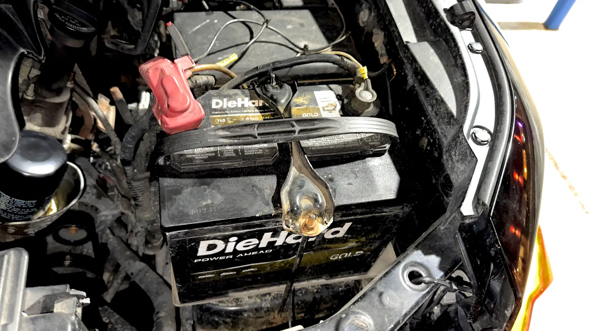 Toyota FJ Cruiser engine bay with battery hold downs re-securing the battery in its tray after shifting loose.
