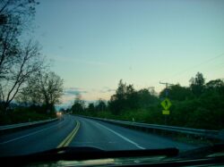 Image through the windshield of a Toyota FJ Cruiser of a 2 lane rural highway at dusk with traffic ahead.